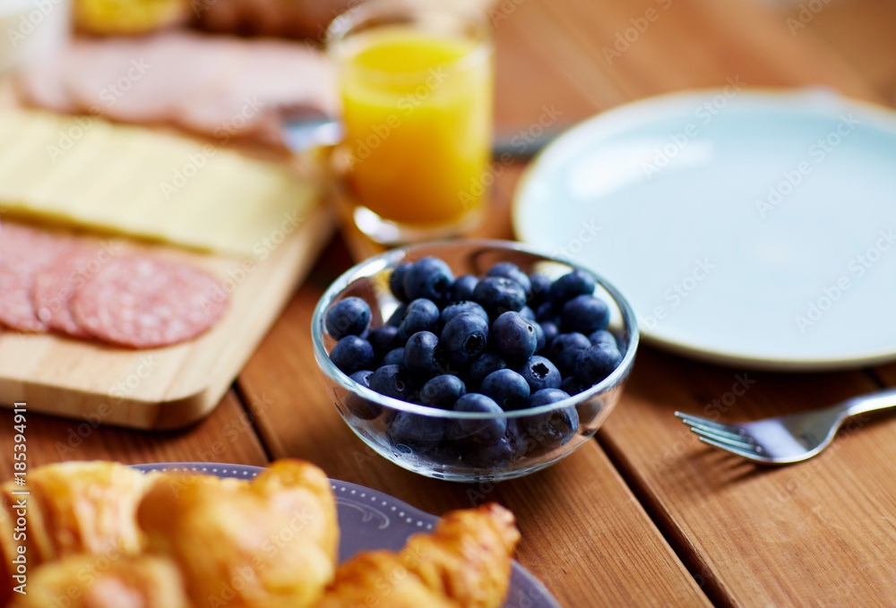 bowl of blueberries on wooden table at breakfast bowl of blueberries on wooden table at breakfast
