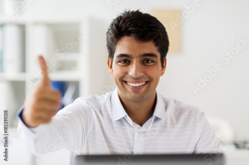 businessman showing thumbs up at office