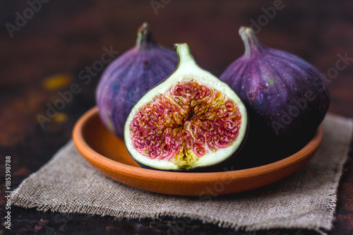 Fig fruits on clay plate on dark background. photo