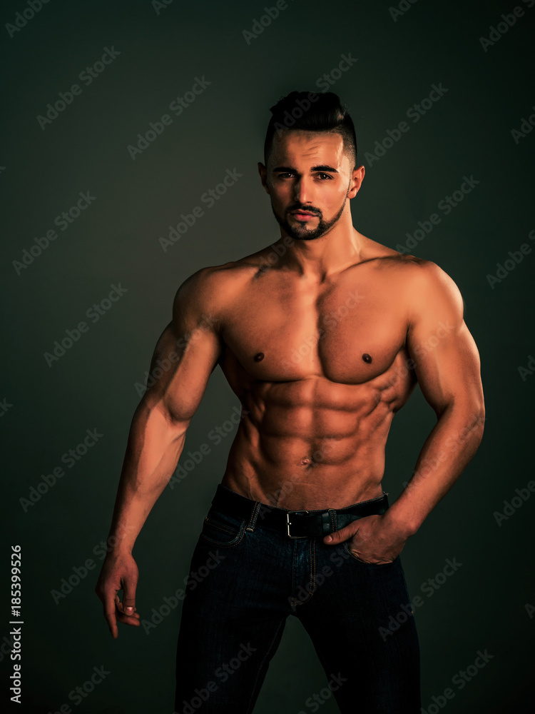 Athletic bodybuilder man on black background.