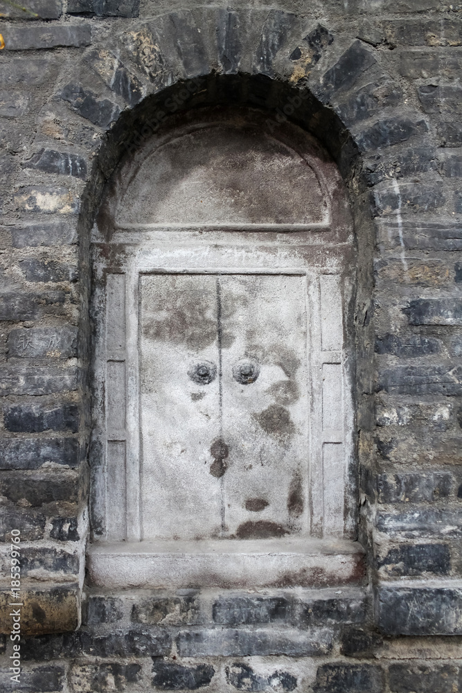 Old steel closed window in the ancient Chinese temple. Brick wall texture Old steel closed window in the ancient Chinese temple. Brick wall texture