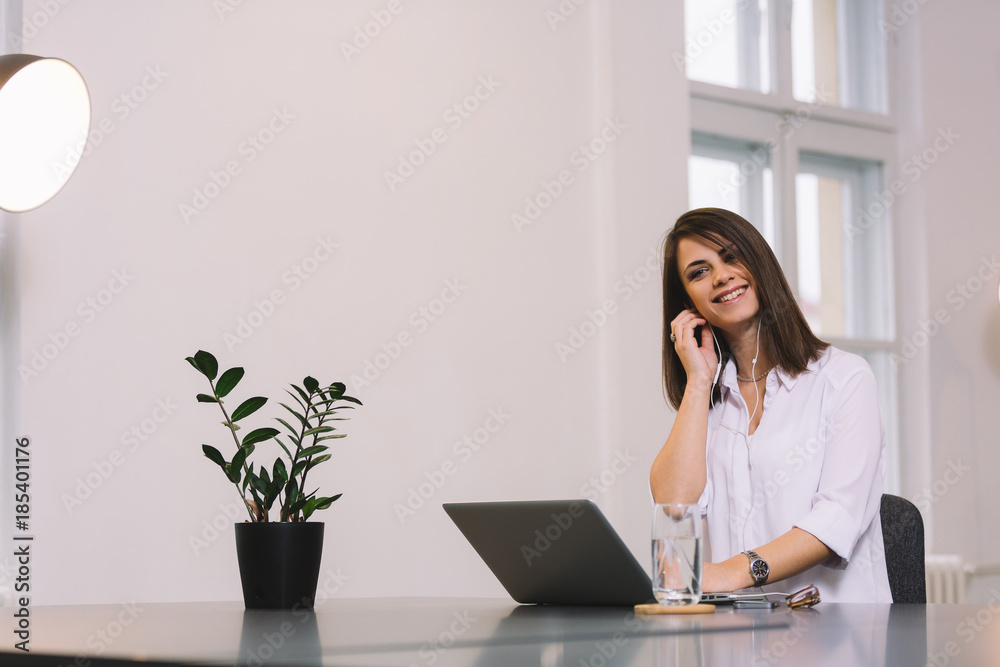 Young pretty brunette enjoying at her office. Girl listening to the music. Young pretty brunette enjoying at her office. Girl listening to the music.