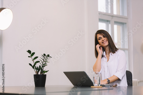 Young pretty brunette enjoying at her office. Girl listening to the music. © Nebojsa
