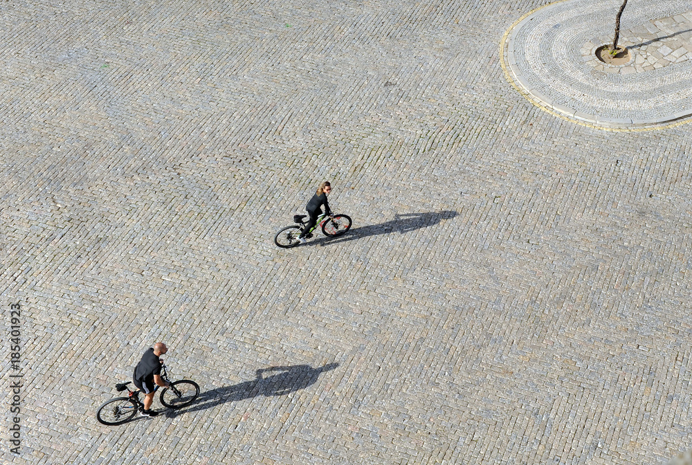 Fototapeta premium Couple of tourists making a sightseeing city tour by bike on image taken from above