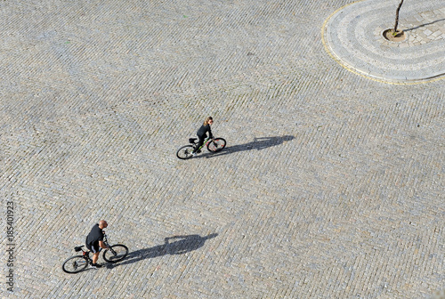 Couple of tourists making a sightseeing city tour by bike on image taken from above