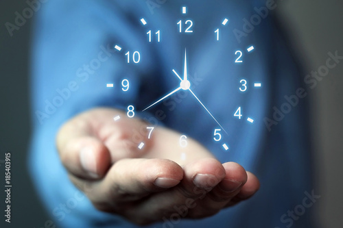 Businessman holding clock. Concept of saving time.