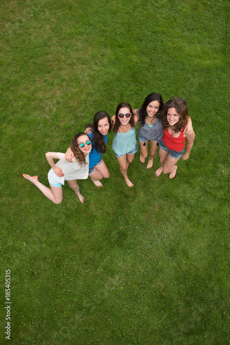 Top view. Group of young women outdoors, barefoot in the grass