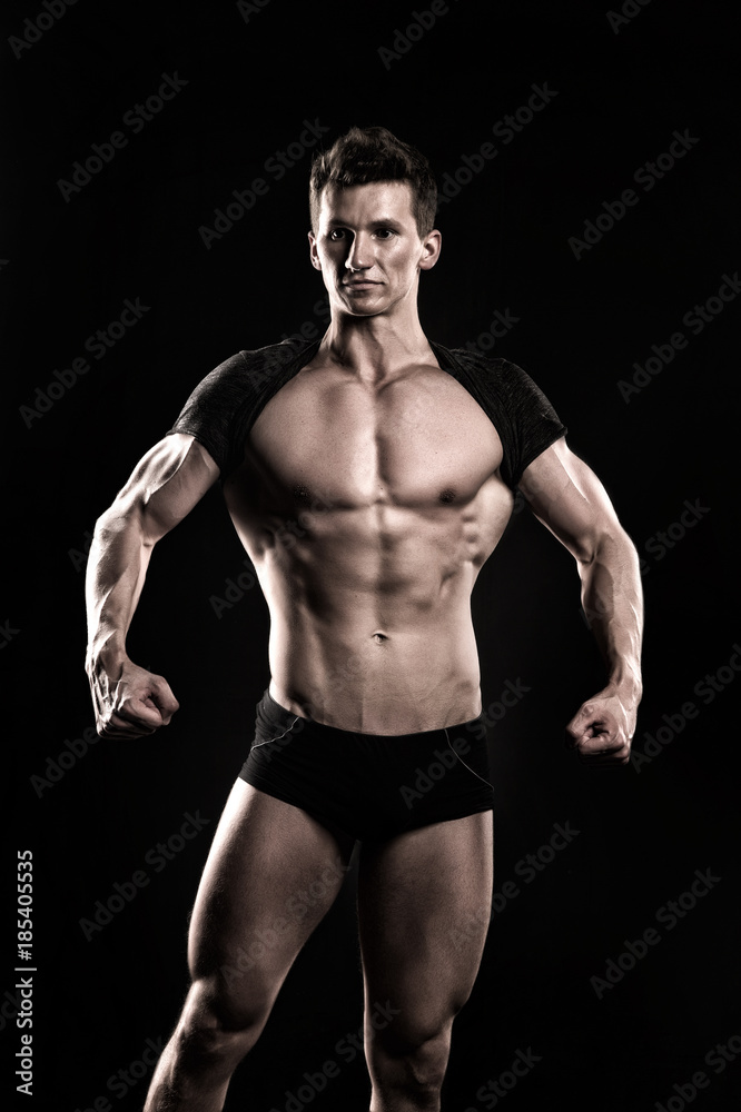Bodybuilder show muscular body on dark background