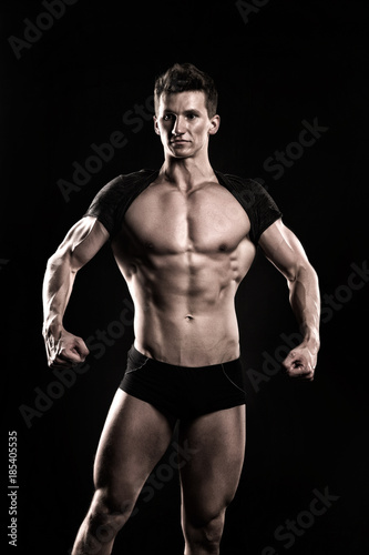 Bodybuilder show muscular body on dark background