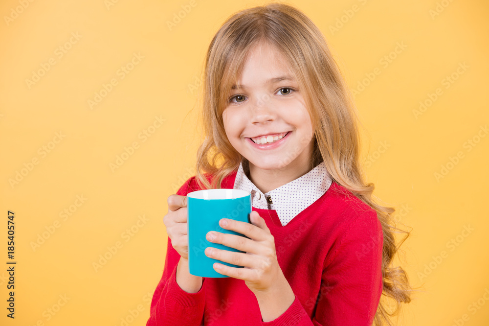 Child smile with blue cup on orange background Child smile with blue cup on orange background