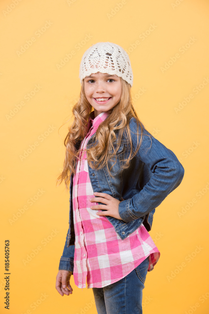 Girl in jeans suit, hat, plaid shirt on orange background Girl in jeans suit, hat, plaid shirt on orange background