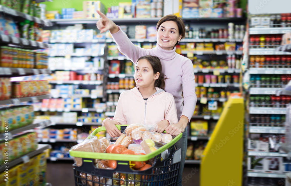 Glad woman and daughter with shopping cart