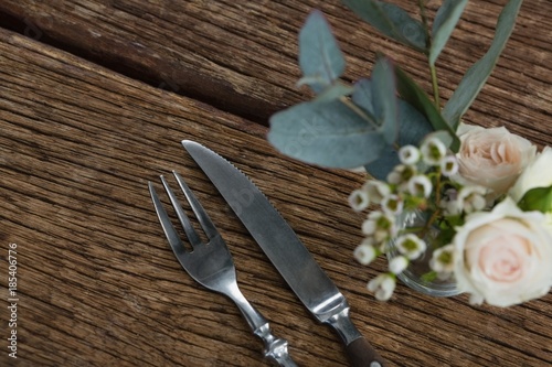 Fork and butter knife with rose flower n wooden table