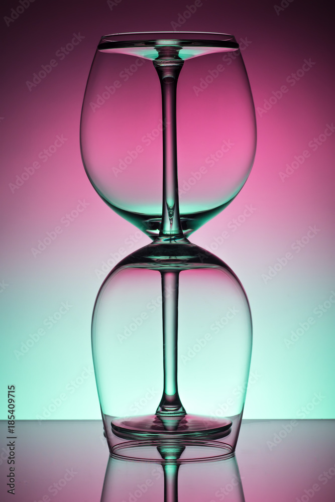 Two empty wineglass for red wine on diffusion lit background in abstract 
 composition with reflection