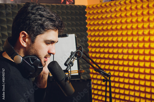 Microphone in radio studio and presenter on background photo