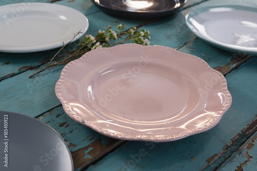 Fototapeta Naklejka Na Ścianę i Meble -  Empty plates with flower on wooden table