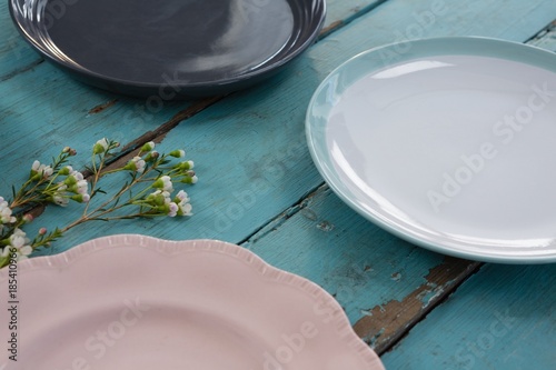 Fototapeta Naklejka Na Ścianę i Meble -  Empty plates with flower on wooden table