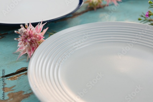 Fototapeta Naklejka Na Ścianę i Meble -  Empty plate with flower on wooden table