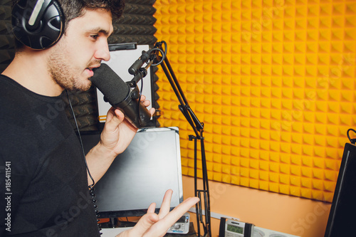 Microphone in radio studio and presenter on background photo
