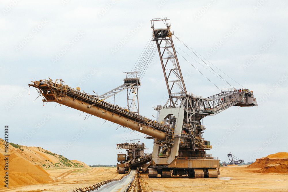 coal mining. Giant wheel of bucket wheel excavator. Long conveyor belt transporting ore