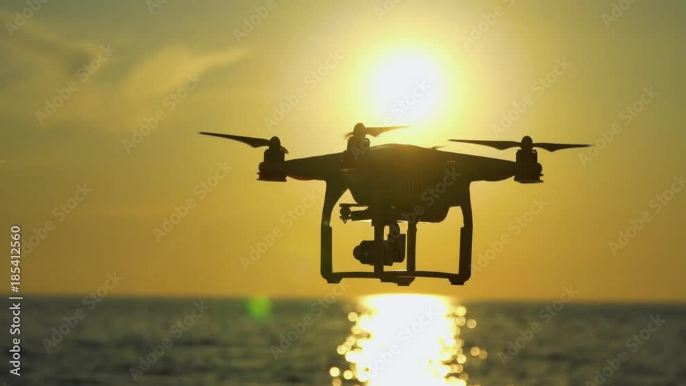 The drone in the sunset sky. ocean wave mountains Close up of quadrocopter outdoors. concept for film maker wedding videography aerial photographer. equipment for The drone in the sunset sky. ocean wave mountains Close up of quadrocopter outdoors. concept for film maker wedding videography aerial photographer. equipment for