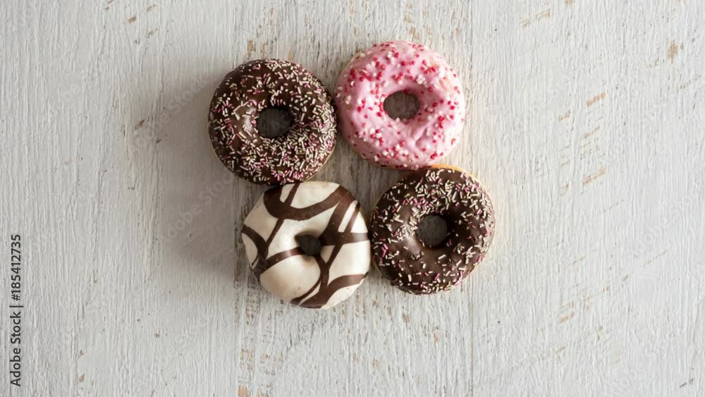 Stop motion of donuts on white wooden background. Delicious junk food Stop motion of donuts on white wooden background. Delicious junk food
