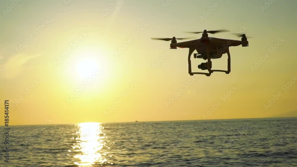 The drone in the sunset sky. ocean wave mountains Close up of quadrocopter outdoors. concept for film maker wedding videography aerial photographer. equipment for The drone in the sunset sky. ocean wave mountains Close up of quadrocopter outdoors. concept for film maker wedding videography aerial photographer. equipment for