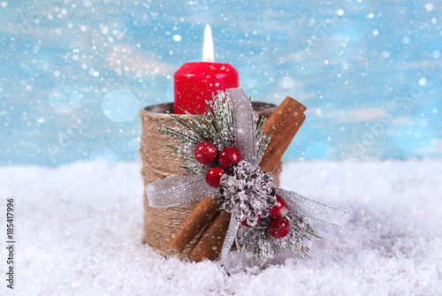 New Year background with a candle on a snowfall background