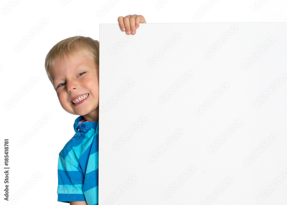 A little boy is looking from behind an empty banner. A little boy is looking from behind an empty banner.