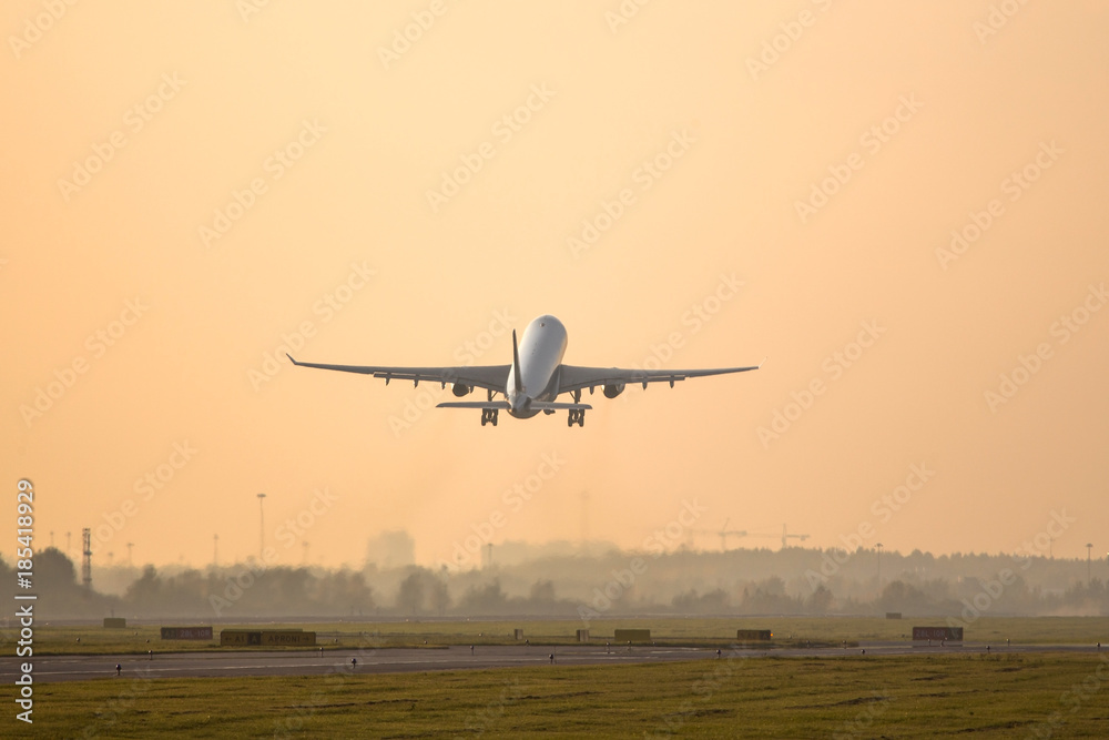 airplane taking off on sunset above the runway /plane fly up at sunset yellow sky background /Lifting force airplane/ airplane taking off on sunset above the runway /plane fly up at sunset yellow sky background /Lifting force airplane/