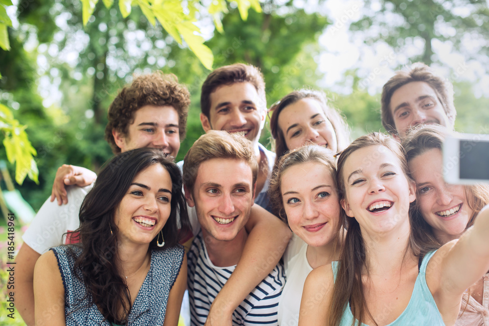 Group of young people taking a selfie outside Group of young people taking a selfie outside