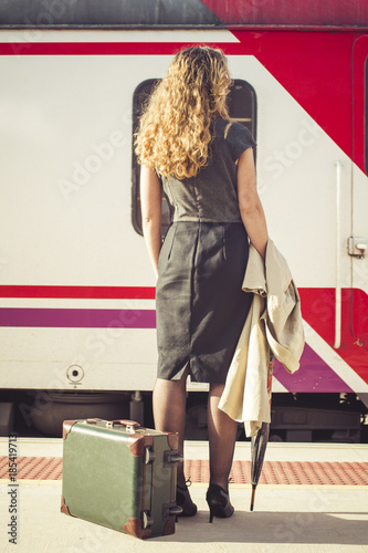 Portrait of a woman watching the train going by, she remains on the platform