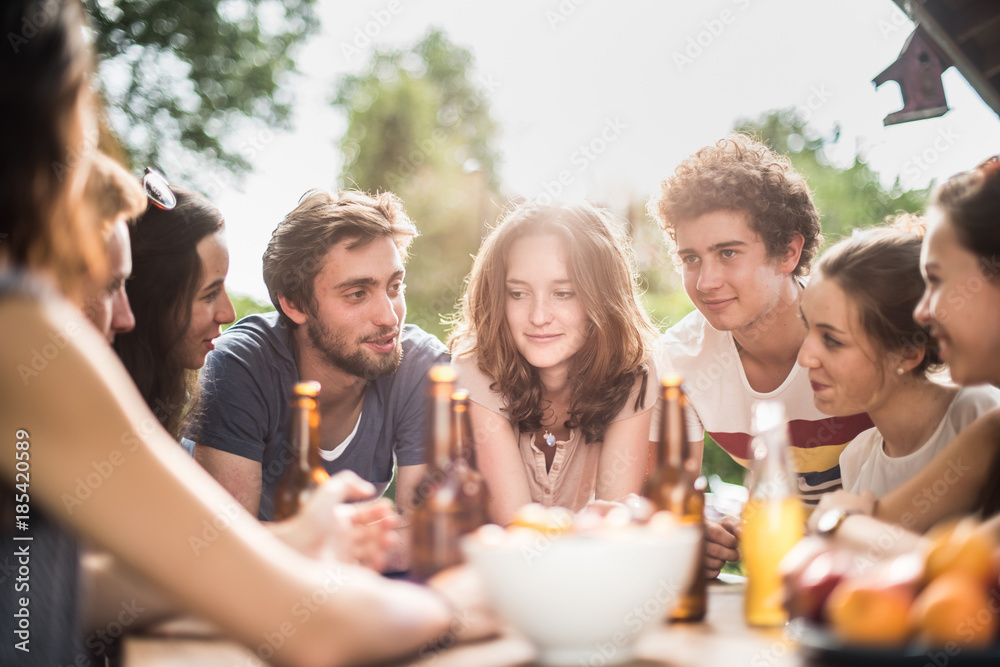 Obraz premium Group of young people sitting around a table outside