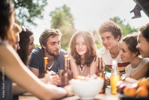 Group of young people sitting around a table outside