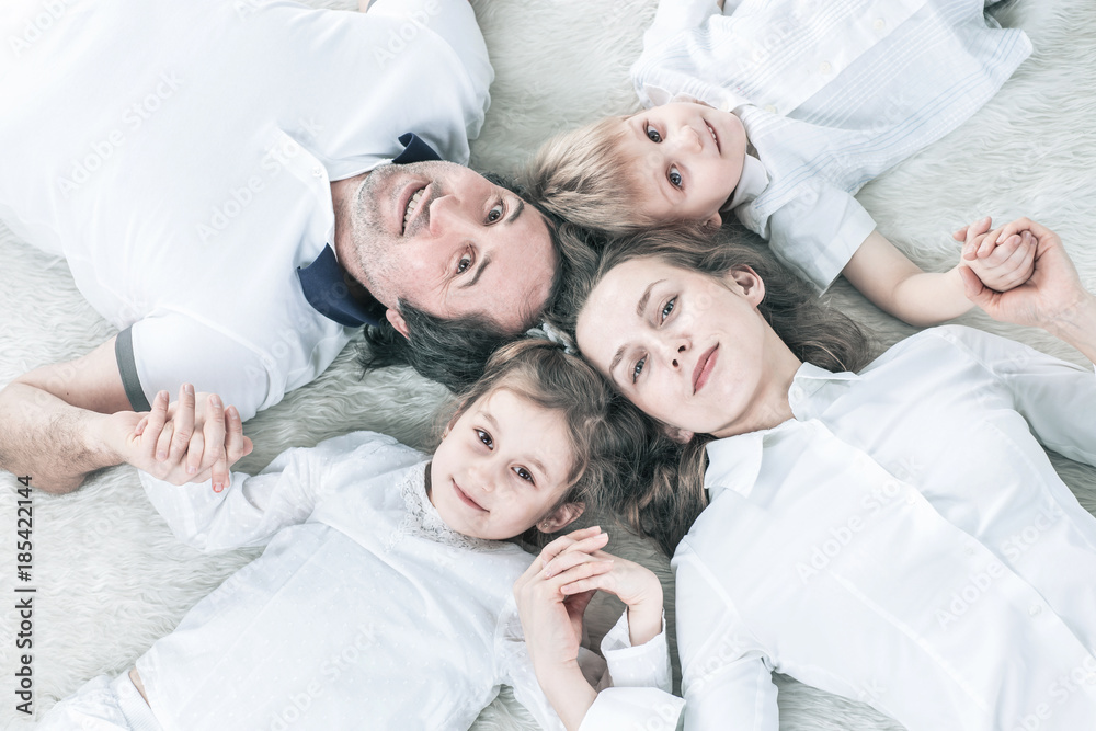 concept of family happiness: happy family relaxing on the carpet on Sunday