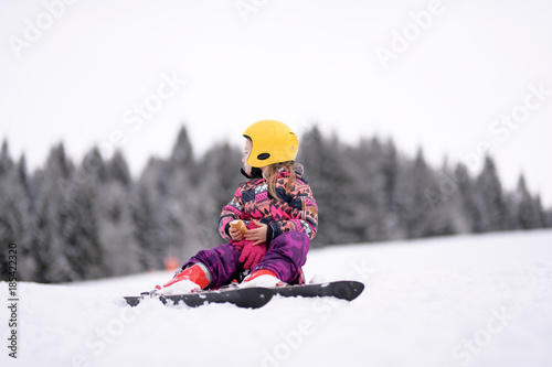Happy little girl skiing downhill