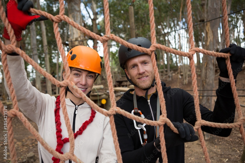 Obraz premium Couple wearing safety helmet holding and posing through a rope