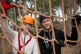Couple wearing safety helmet holding and posing through a rope