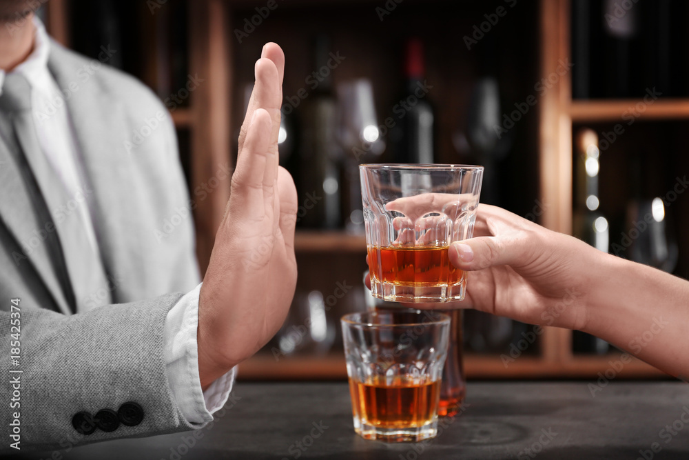 Man rejecting glass of alcohol in bar. Healthy lifestyle concept Man rejecting glass of alcohol in bar. Healthy lifestyle concept