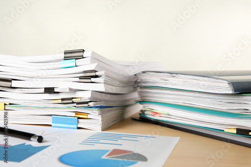 Stacks of documents on table against light background