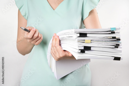 Woman with stack of documents against white background photo