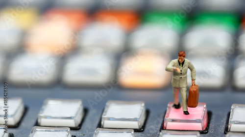 Miniature people : business man looking at watch and walk on the switcher control of Television Broadcast,color buttons