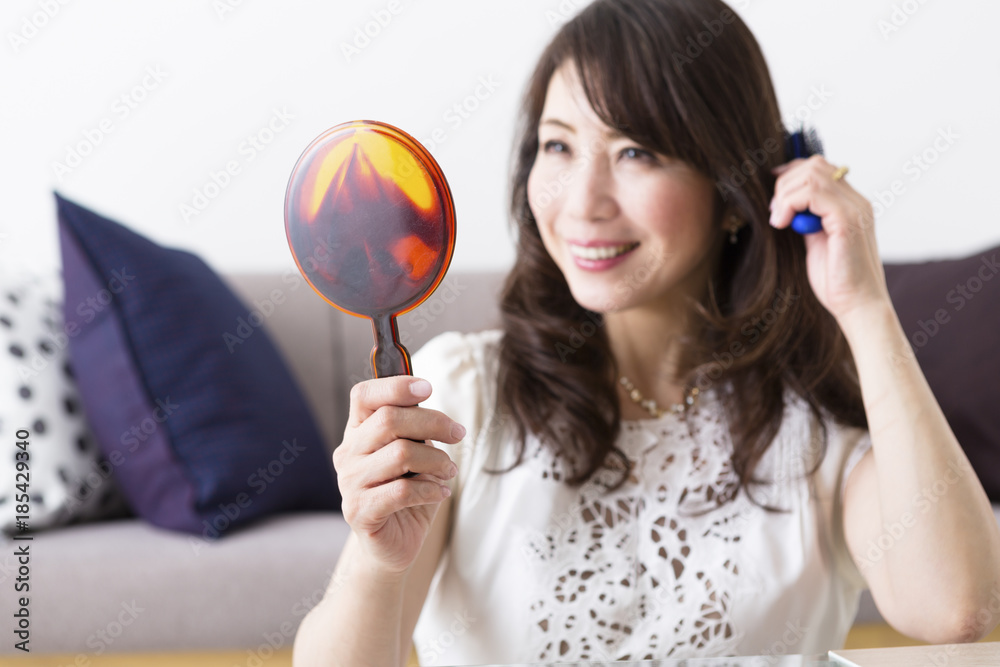 髪をとかすミドル女性 髪をとかすミドル女性