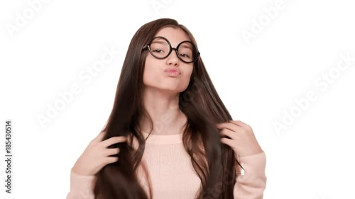 Portrait of young funny woman admiring herself wearing trendy glasses fooling around making flirty face over white background in studio. Concept of emotions