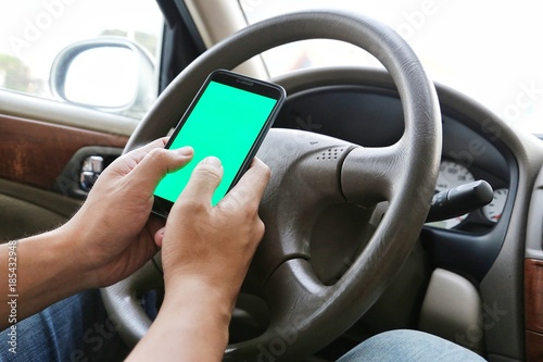 Man Using his mobile phone while driving. Dangerous driver. Blue / Green Screen. Concept and idea of safety driving © nutcd32