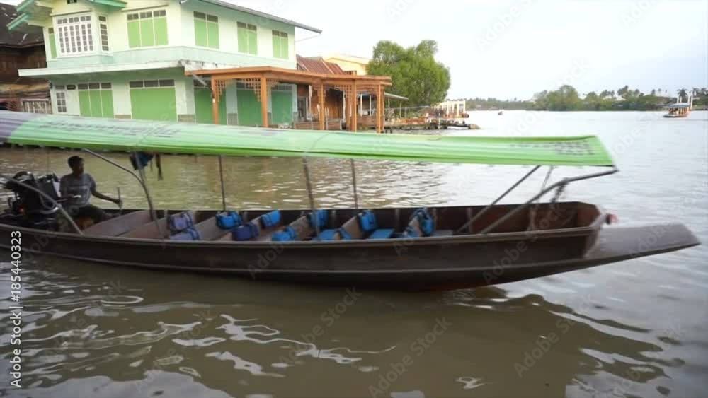 Amphawa,Thailand.December 2,2017. thai local passenger boat for tourist with driver is sailing pass through mae klong river. Amphawa,Thailand.December 2,2017. thai local passenger boat for tourist with driver is sailing pass through mae klong river.