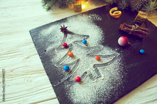 Christmas tree made from flour on a black background with anise stars and cinnamon sticks. Merry Christmas photo