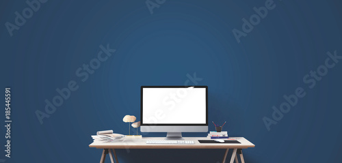 Computer display and office tools on desk.
