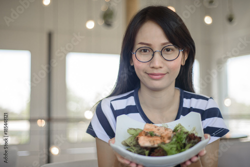 Closeup on Asian woman showing salmon salad.