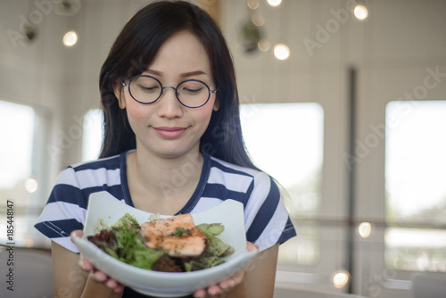 Closeup on Asian woman showing salmon salad.